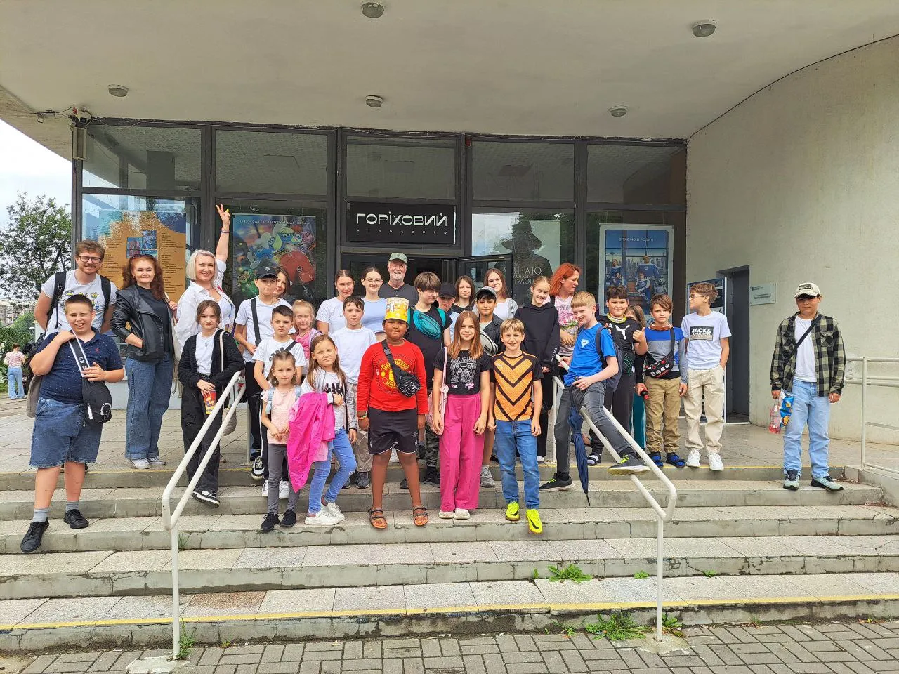 Campers and volunteers together on the steps of a museum during a day out
