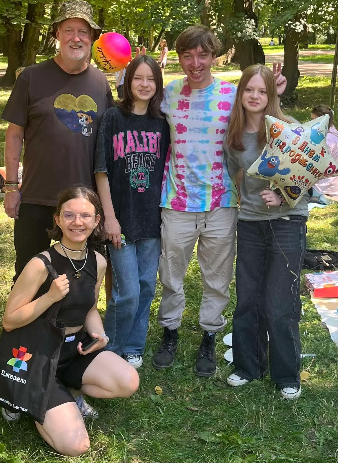 Founder Bernie Hogan with a group of teenage campers in a park